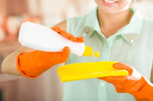 Professional cleaner refreshing a bathroom and kitchen for short-term guests